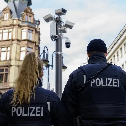 Zwei Polizisten stehen direkt unter einer Videoüberwachungs-Anlage im Frankfurter Bahnhofsviertel. Nach mehreren Jahren Vorlauf hat die Stadt Frankfurt eine neue Anlage zur Videoüberwachung im Bahnhofsviertel vorgestellt. Die Kriminalitätsbekämpfung der Polizei an diesem Brennpunkt soll damit erheblich erleichtert werden.
